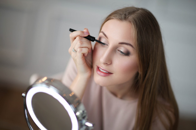 mulher fazendo maquiagem com lente de contato